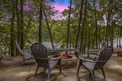 Four chairs around a firepit at dusk